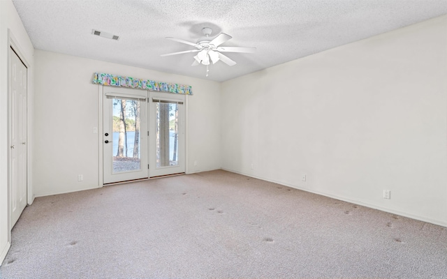 carpeted empty room featuring ceiling fan and a textured ceiling