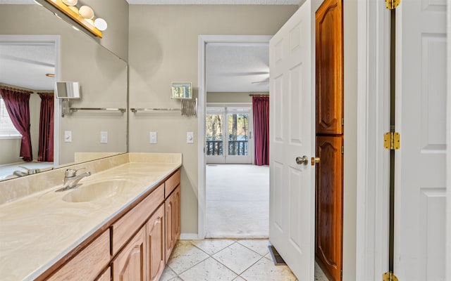 bathroom with tile patterned flooring, a textured ceiling, and vanity