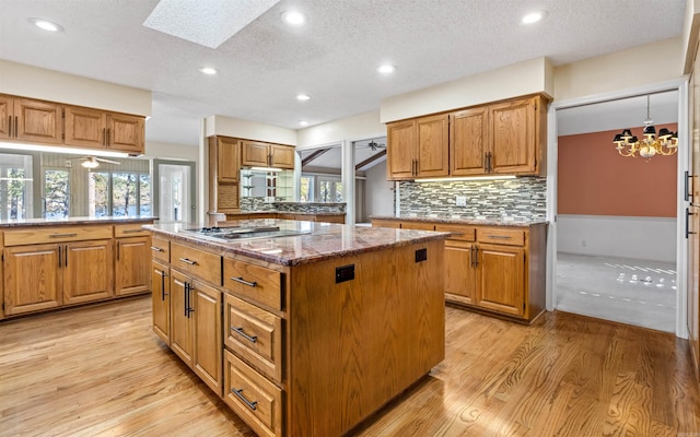 kitchen featuring a textured ceiling, a center island, and light hardwood / wood-style flooring