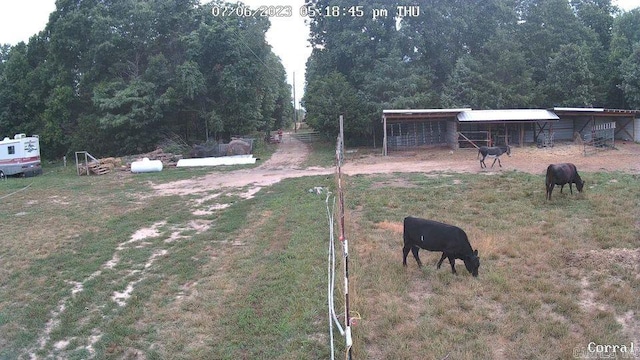 view of yard with a rural view and an outdoor structure