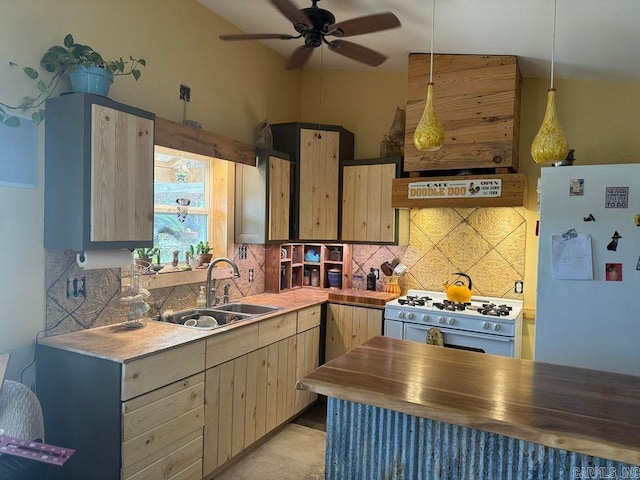 kitchen with sink, pendant lighting, white refrigerator, light brown cabinets, and range with gas stovetop