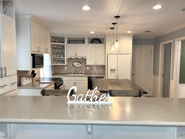 kitchen with white cabinets, sink, tasteful backsplash, decorative light fixtures, and stainless steel appliances