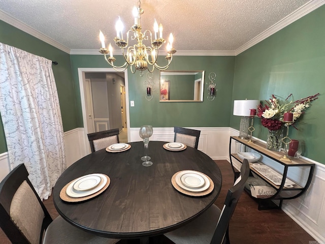 dining space featuring a textured ceiling, crown molding, dark wood-type flooring, and a chandelier