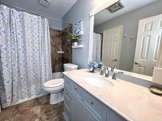 bathroom with tile patterned floors, vanity, toilet, and a textured ceiling