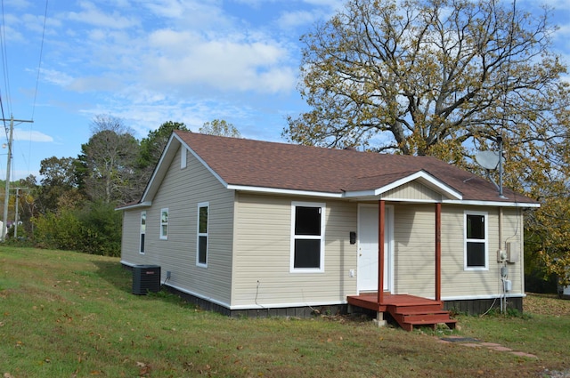 view of front of home featuring a front yard and central AC