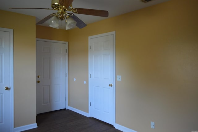 unfurnished bedroom with dark hardwood / wood-style floors and ceiling fan