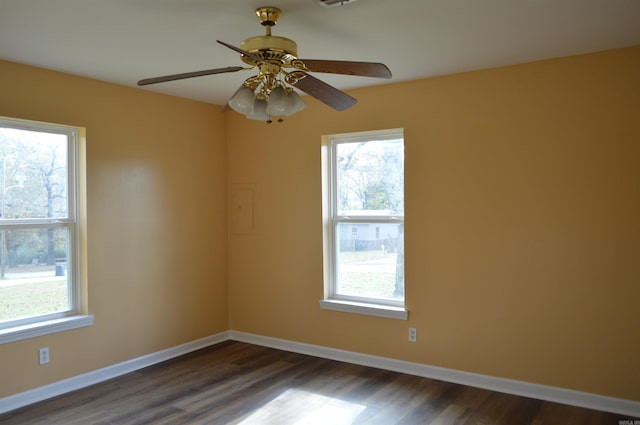 empty room featuring plenty of natural light, dark hardwood / wood-style floors, and ceiling fan