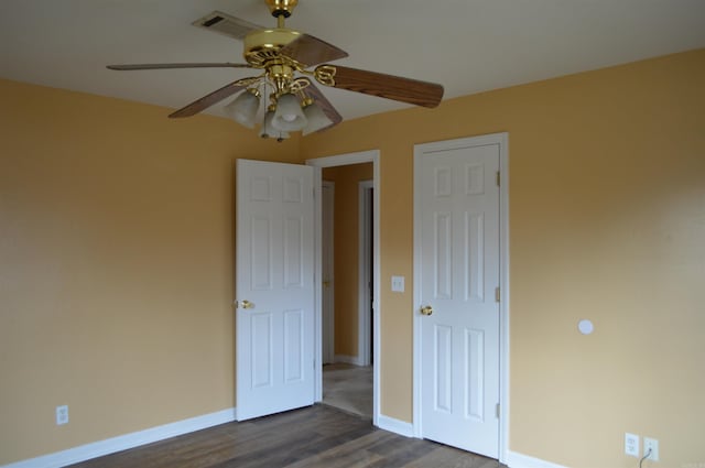 unfurnished bedroom featuring ceiling fan and dark wood-type flooring