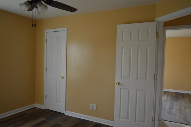 unfurnished bedroom featuring ceiling fan and dark wood-type flooring