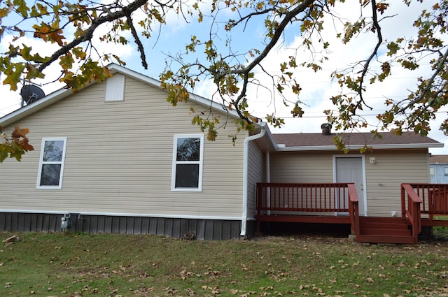 back of property featuring a yard and a deck