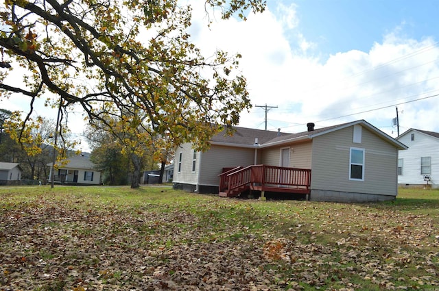 rear view of house featuring a yard and a deck