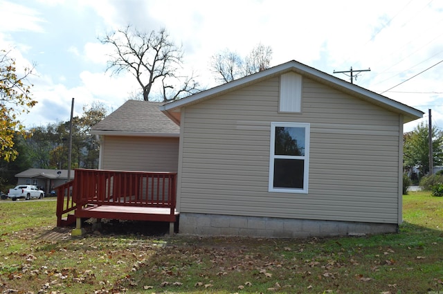 view of side of home with a lawn and a wooden deck