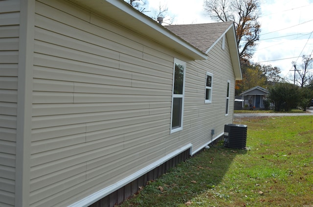 view of property exterior with central air condition unit and a lawn