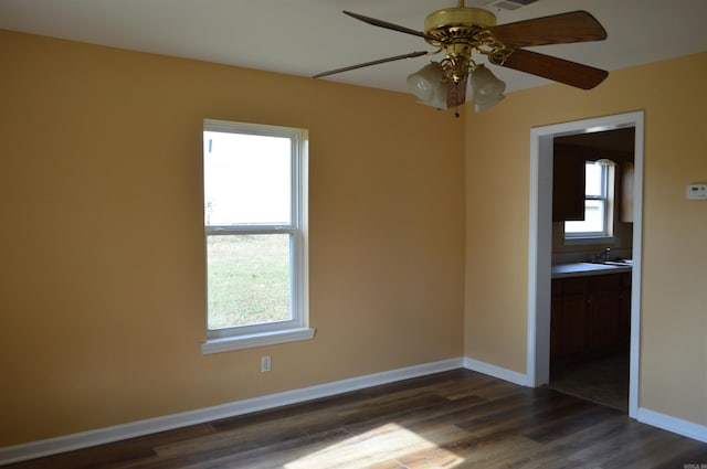 spare room featuring ceiling fan and dark wood-type flooring