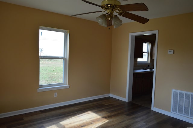 spare room featuring ceiling fan and dark wood-type flooring