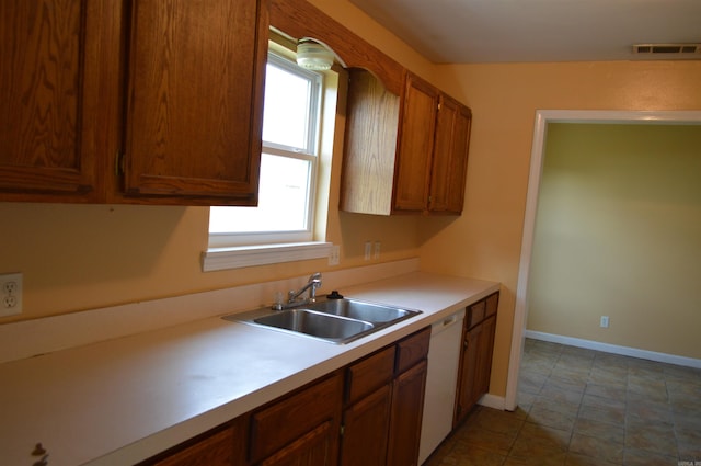 106 W Clinton, Heber Springs, AR 72543 - kitchen with a sink, light countertops, brown cabinets, white dishwasher, and baseboards