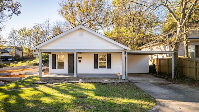 bungalow featuring a carport, covered porch, and a front yard