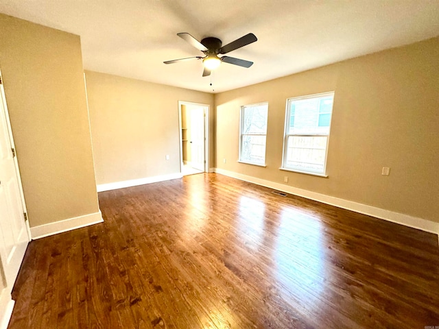 empty room with dark wood-type flooring and ceiling fan