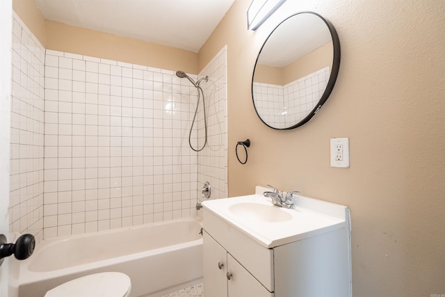 full bathroom with vanity, tiled shower / bath, and toilet