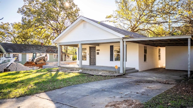 view of front facade featuring a front yard, a carport, and a porch