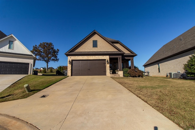 craftsman-style house featuring a front yard, central air condition unit, and concrete driveway