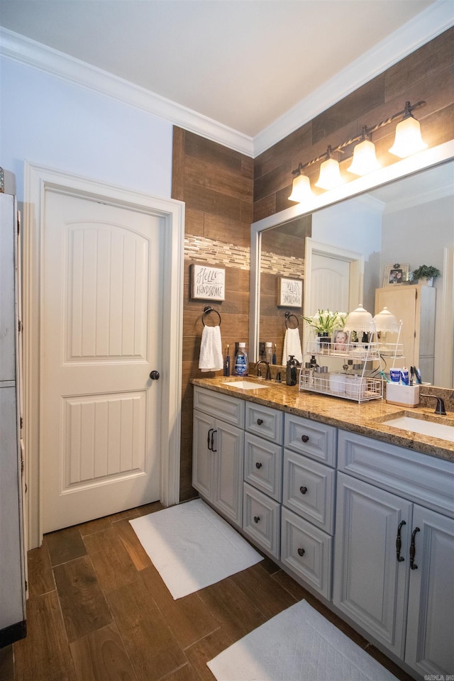 bathroom with vanity, wood-type flooring, crown molding, and tasteful backsplash