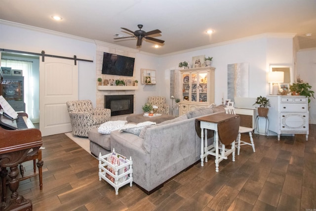 living room with dark hardwood / wood-style floors, a barn door, crown molding, and ceiling fan