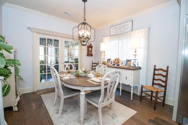 dining area with crown molding, dark wood-type flooring, and an inviting chandelier