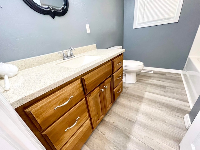 bathroom with vanity, wood-type flooring, and toilet