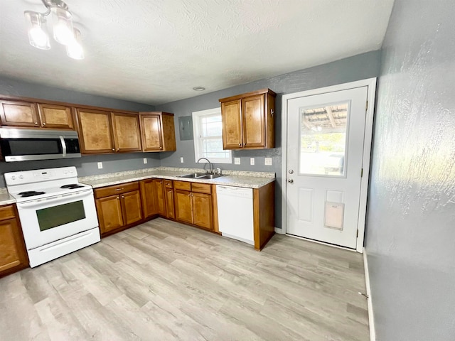 kitchen with sink, white appliances, electric panel, a textured ceiling, and light hardwood / wood-style flooring