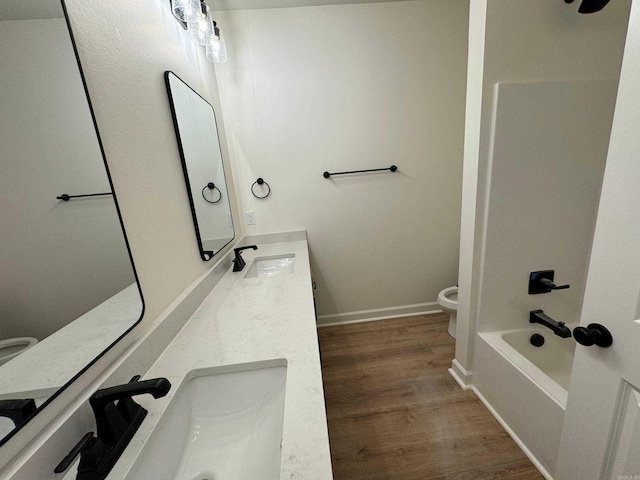 full bathroom with hardwood / wood-style floors, vanity, toilet, and shower / bathtub combination