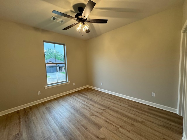 spare room featuring wood-type flooring and ceiling fan