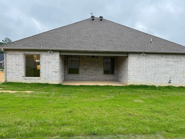 rear view of house with a yard and a patio