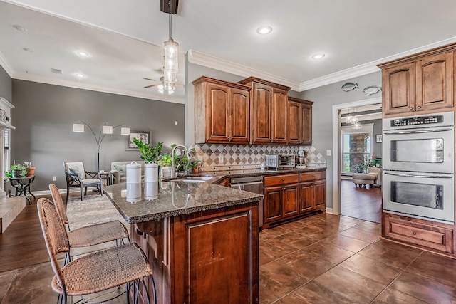 kitchen featuring sink, kitchen peninsula, stainless steel appliances, and ornamental molding