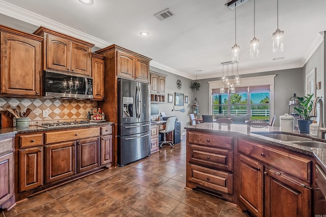 kitchen with crown molding, sink, stainless steel appliances, and decorative light fixtures