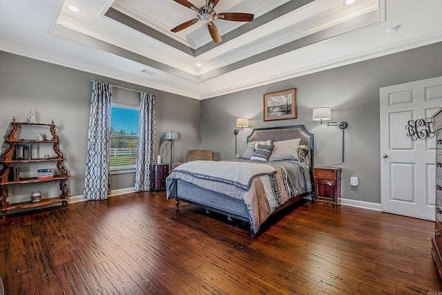 bedroom with a tray ceiling, dark hardwood / wood-style flooring, ceiling fan, and crown molding