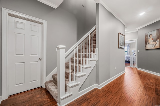 stairs featuring hardwood / wood-style floors and ornamental molding