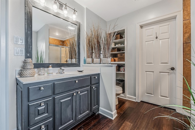 bathroom with vanity, hardwood / wood-style flooring, toilet, and a shower with door