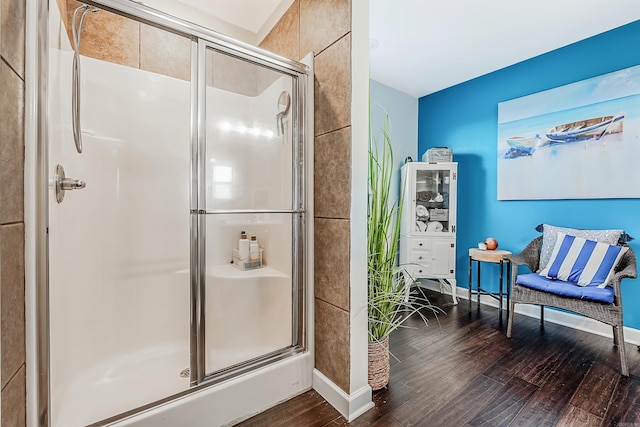 bathroom featuring wood-type flooring and a shower with shower door