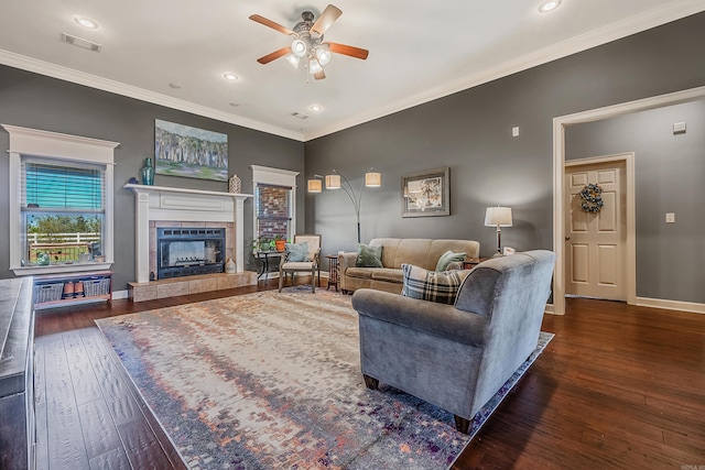 living room with crown molding, a fireplace, ceiling fan, and dark hardwood / wood-style floors