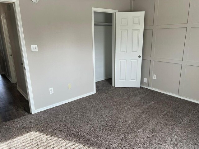 unfurnished bedroom with dark carpet