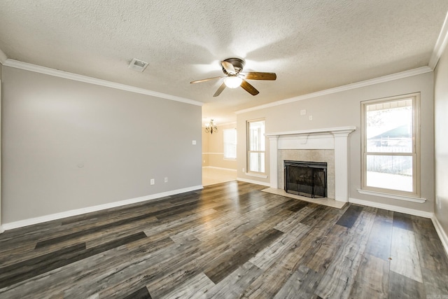 unfurnished living room featuring dark hardwood / wood-style floors, ornamental molding, a textured ceiling, and a tile fireplace