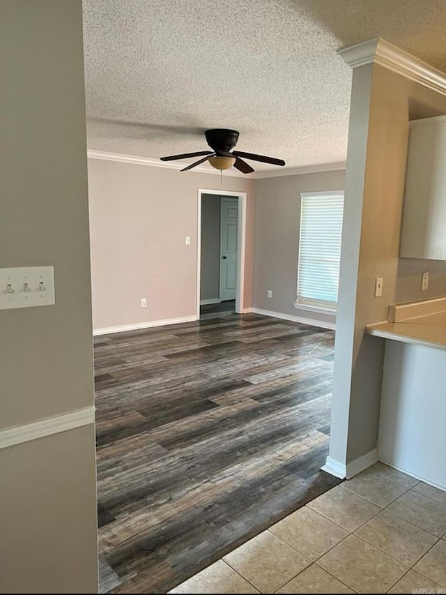 unfurnished room with ceiling fan, crown molding, wood-type flooring, and a textured ceiling