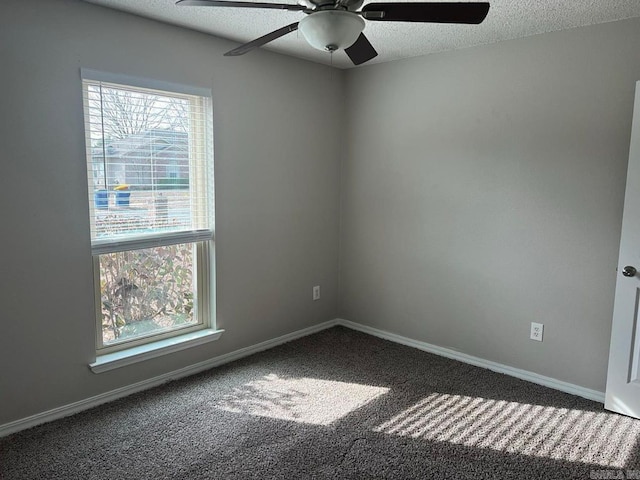 empty room featuring a textured ceiling, carpet floors, ceiling fan, and a healthy amount of sunlight