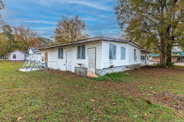 view of side of home featuring a lawn and a playground