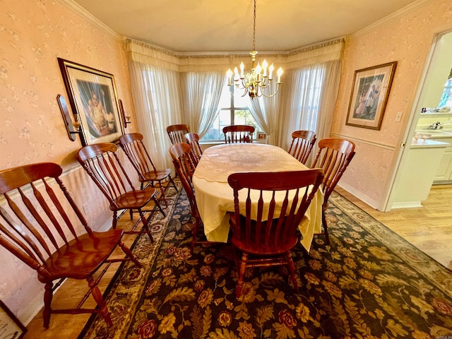 dining room featuring hardwood / wood-style flooring, ornamental molding, sink, and a notable chandelier