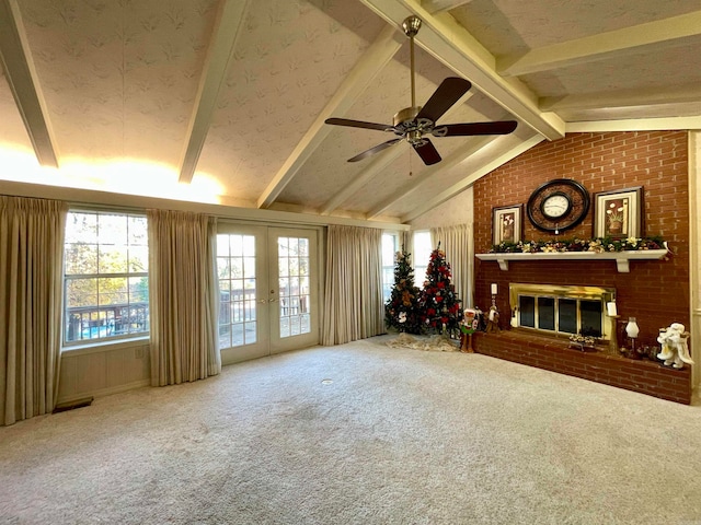 carpeted living room featuring a brick fireplace, vaulted ceiling with beams, ceiling fan, and french doors