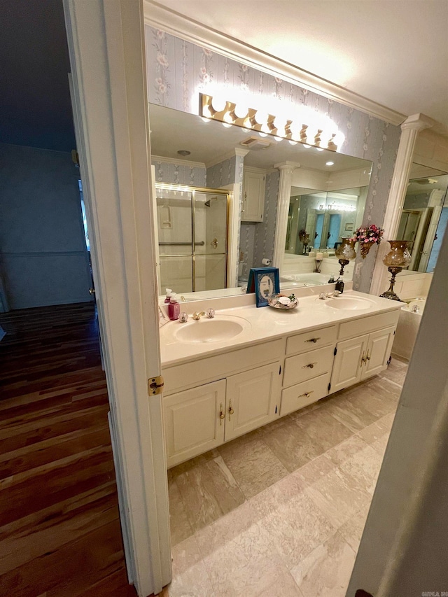 bathroom featuring ornamental molding, a shower with door, vanity, and ornate columns