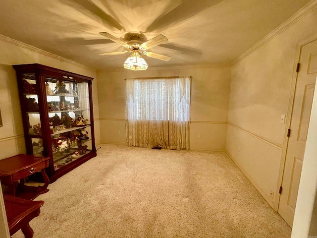 empty room featuring crown molding, carpet, and ceiling fan