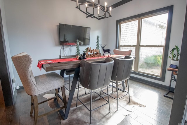 dining area with a healthy amount of sunlight, wood-type flooring, and a chandelier